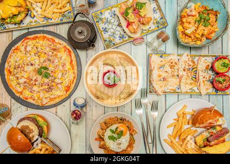 Piatti internazionali. Italian Pizza, quesadillas messicane, Gyozas asiatiche, Aella spagnola, poke hawaiano, Hamburger americani Foto Stock