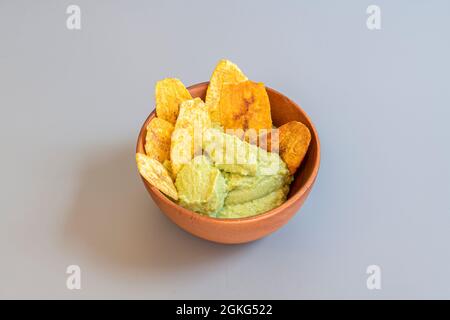 Ciotola in legno con nuova ricetta per hummus edamame con patatine di plantain Foto Stock