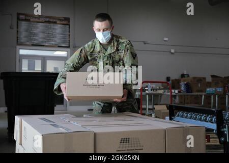 SPC dell'esercito degli Stati Uniti. Jacob Thompson, un idraulico con il Land Dominance Center di Fort Stewart, 78° comando di truppe, Guardia Nazionale dell'Esercito della Georgia, si accatasta una scatola di cibo il 14 aprile 2021, presso la seconda banca alimentare americana Harvest of Coastal Georgia a Savannah, Georgia. I guardiani della Georgia hanno fornito sostegno alle banche alimentari di tutto lo Stato per aiutare i cittadini in necessità durante la pandemia del COVID-19. Foto Stock