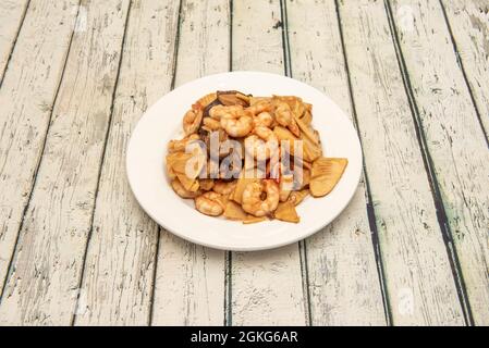 Ricetta tipica e super gustosa da un ristorante cinese. Gamberi saltati con bambù e funghi cinesi Foto Stock