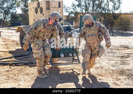 Soldati dell'esercito degli Stati Uniti dalla Task Force Spartan Division Tactical- Jordan, i Lt. Nick Hergenrother da Mansfield, Texas, e SPC. Francisco Resendez, di Brownsville, Texas, aiuta a spostare un sistema di illuminazione per la distribuzione dell'alimentazione durante il trasferimento di un esercizio tattico del centro operativo, noto come “jumping the TAC”, 14 aprile 2021. I soldati hanno lavorato insieme per proteggere la zona e hanno posto più di un miglio di filo di concertina. I Signal Soldiers garantivano che la rete informatica fosse immediatamente operativa e in grado di fornire lo stesso livello critico di consapevolezza situazionale al comando. Questo validati Foto Stock