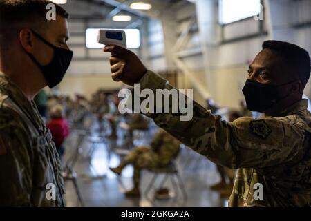 Personale Sgt. Kwayme Kennedy (a destra), ingegnere geospaziale, quartier generale e sede centrale, 555th Ingegnere Brigade, misura le temperature prima di un municipio pronto esercizio presso la 110th Chemical Battaglione sede presso la Joint base Lewis-McChord, 15 aprile 2021. Questa opportunità di formazione consente alle unità di sviluppare e sostenere la nostra disponibilità durante il funzionamento in un ambiente COVID-19. Foto Stock