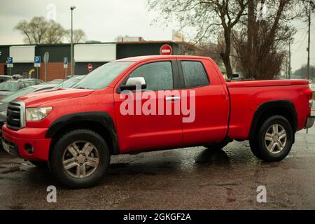 Un SUV rosso è parcheggiato in città. Il pick-up è su un groan. Vettura grande. Foto Stock