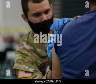 MANGILAO, Guam (16 aprile 2021) – PFC. Ethan Van Veldhuizen, uno specialista di medaglie di combattimento assegnato alla 25a Divisione di fanteria, somministra un vaccino COVID-19 a sostegno del team di vaccinazione COVID-19 del Dipartimento di Sanità pubblica e servizi sociali di Guam (DPHSS) presso una clinica di vaccinazione tenuta presso la Field House dell'Università di Guam Calvo. Il comando IndoPacifico degli Stati Uniti, attraverso l'Esercito Pacifico degli Stati Uniti, continua a fornire supporto flessibile al Dipartimento della Difesa dell'Agenzia federale per la gestione delle emergenze come parte della risposta dell'intero governo al COVID-19. Foto Stock