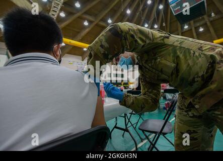 MANGILAO, Guam (16 aprile 2021) – PFC. Ethan Van Veldhuizen, uno specialista di medaglie di combattimento assegnato alla 25a Divisione di fanteria, somministra un vaccino COVID-19 a sostegno del team di vaccinazione COVID-19 del Dipartimento di Sanità pubblica e servizi sociali di Guam (DPHSS) presso una clinica di vaccinazione tenuta presso la Field House dell'Università di Guam Calvo. Il comando IndoPacifico degli Stati Uniti, attraverso l'Esercito Pacifico degli Stati Uniti, continua a fornire supporto flessibile al Dipartimento della Difesa dell'Agenzia federale per la gestione delle emergenze come parte della risposta dell'intero governo al COVID-19. Foto Stock