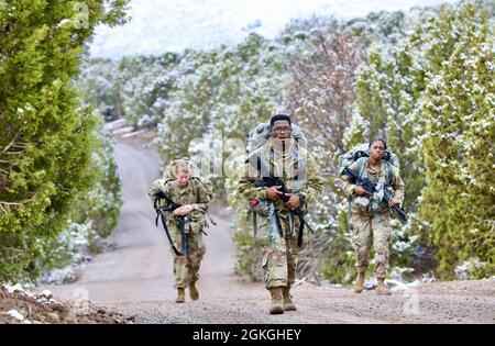 Personale della Riserva dell'esercito Sgt. Jonathan Boyden (centro), un M1135 Nuclear, Biological, Chemical, Reconnaissance Vehicle Commander e nativo di Shreveport, Louisiana, assegnato alla 327th Chemical Company, 415th Chemical Brigade, 76th Operational Response Command, e due altri soldati della Army Reserve conducono una marcia in ruck lungo una strada nevosa a Camp Williams, Utah, aprile 16. Boyden è stato uno dei quindici soldati della Riserva dell'Esercito da tutto il paese che recentemente è venuto a Camp Williams per competere in una competizione del miglior guerriero del comando congiunto che ha sfidato i soldati con cinque giorni di fisico rigoroso e m Foto Stock