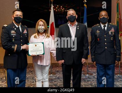 Thomas Matelski (a sinistra) e Command Sgt. Il maggiore Justin Turner (a destra) presenta Janet Niederriter alla medaglia di elogio del Servizio pubblico durante la cerimonia di ritiro di J. Steve Niederriter il 16 aprile 2021, a Camp Zama, Giappone. Foto Stock