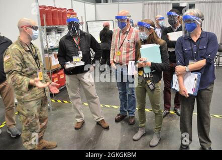 Guardia nazionale dell'esercito di New York Maj Michael Thompson (sinistra) operazioni congiunte LNO, JFHQ-NY, Parla con i rappresentanti degli Stati Uniti Centers for Disease Control and Prevention (CDC), l'agenzia federale nazionale di sanità pubblica degli Stati Uniti sotto il Dipartimento di Salute e servizi umani durante la loro visita in loco presso il sito di vaccinazione di massa dello Stato di New York presso il Jacob Javits Center, New York City il 17 aprile 2021. Oltre 3,180 membri dell'Esercito di New York e della Guardia Nazionale aerea, della milizia Navale di New York e della Guardia di New York stanno sostenendo la risposta multi-agenzia al COVID-1 Foto Stock