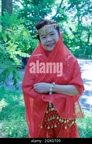 Ritratto posto di una donna nella troupe di danza Kai Xin Yizhu. Dopo uno spettacolo che celebra l'anniversario dei gruppi. A Queens, New York. Foto Stock