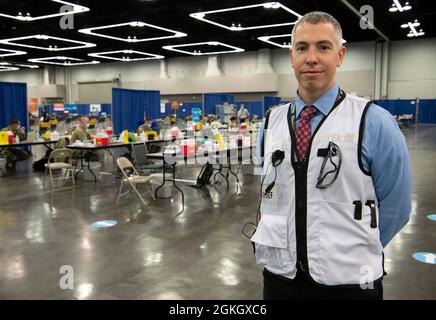 Chris Markesino, capo delle operazioni di vaccinazione di massa dell'Oregon Convention Center e membro della Guardia Nazionale dell'Oregon Army, fa una pausa per scattare una fotografia all'Oregon Convention Center prima dell'apertura del sito il 19 aprile 2021. Il 6 aprile, il presidente Joe Biden ha annunciato che tutti gli adulti americani avrebbero potuto beneficiare di un vaccino contro il coronavirus entro la data odierna, in quanto gli Oregon Guardsmen hanno ora somministrato oltre 300,000 vaccinazioni da quando sono stati attivati. Foto Stock