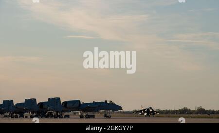 Un AV-8B Harrier, assegnato a Marine Attack Squadron 223, Cherry Point, North Carolina, tassazioni di fronte A A-10 Thunderbolt IIS dalla 124a ala Fighter a Gowen Field, Boise, Idaho, 19 aprile 2021. L'aereo stava ritornando da una prima sera sortie a sud di Mountain Home, Idaho. Foto Stock