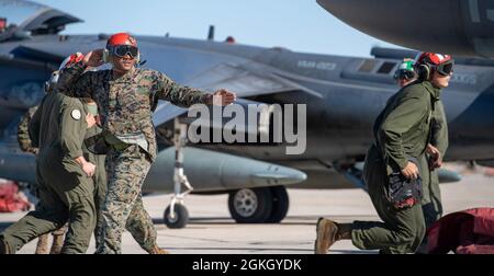 CPL. Marino Calvin, assegnato a Marine Attack Squadron 223, Cherry Point, North Carolina, segnala ad un pilota mentre un collega Marine controlla il carico di un AV-8B Harrier prima di un volo in prima serata a Gowen Field, Boise, Idaho, 19 aprile 2021. Marines da una varietà di abilità aiutano a lanciare ogni velivolo. Foto Stock