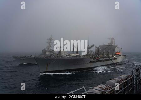 OCEANO PACIFICO (19 aprile 2021) Oiler di rifornimento della flotta USNS Henry J. Kaiser (T-AO-187), centro, conduce un rifornimento in mare (RAS) con cacciatorpediniere missilistico guidato USS Kidd (DDG 100) e nave d'assalto anfibio USS Essex (LHD 2). Le navi stanno conducendo operazioni di routine nella terza flotta degli Stati Uniti. Foto Stock