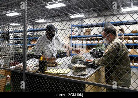 Robins Air Force base, GA. – Terry Walker, 78° Logistics Readiness il gestore di materiali di Squadron, controlla le apparecchiature da Tech. SGT. Logan Romero, 78° responsabile della formazione di unità della direzione delle comunicazioni, presso la base aerea Robins, Georgia, 19 aprile 2021. Gli airman che escono o ritornano dall'attivazione devono arrestarsi dal singolo elemento dell'apparecchiatura di protezione per ricevere o restituire l'attrezzatura. Foto Stock