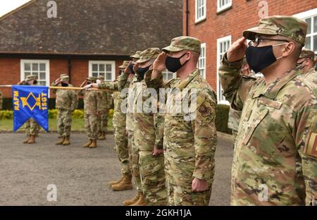 Il team Mildenhall i primi sergente, gli NCO e gli NCO senior salutano durante l'inno nazionale mentre conducono il ritiro alla Royal Air Force Mildenhall, Inghilterra, 20 aprile 2021. Gli Airmen hanno partecipato ad un primo simposio sergente per aiutarli a prepararli come primi sergeanti intermedi. Foto Stock