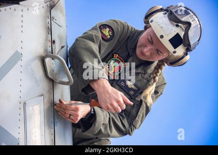 Hannah Lois, un pilota con Marine Light Attack Helicopter Squadron 367, prepara un elicottero UH1-Y Venom per il volo, Marine Corps Air Station Kaneohe Bay, Marine Corps base Hawaii, 21 aprile 2021. Marines con HMLA 367 ha lavorato in concerto con Marine Medium Tiltrotor Squadron 268 e Navy Sailors con Helicopter Maritime Strike Squadron 37 per provare scenari operativi di negazione del mare. Foto Stock