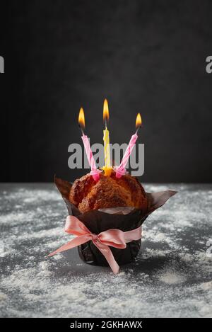 Gustoso cupcake fatto in casa per anniversario di vaniglia o muffin con  numero 50 cinquanta su piatto bianco e sfondo luminoso. Concetto  minimalista di biglietto d'auguri per compleanno. Foto verticale di alta