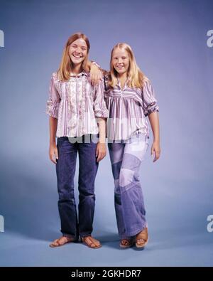 ANNI '70 DUE RAGAZZE ADOLESCENTI IN PIEDI APPOGGIANDOSI L'UN L'ALTRO SORRIDENDO INDOSSANDO JEANS CON FONDO A CAMPANA E CAMICIE A RIGHE GUARDANDO LA MACCHINA FOTOGRAFICA - KJ6520 HAR001 HARS VECCHIA MODA SORELLA 1 GIOVANE STILE BIONDA AMICO COTONE FELICE GIOIA LIFESTYLE SODDISFAZIONE STRIPPED STUDIO SHOT BOTTOM HEALTHINESS HOME VITA COPIA SPAZIO PERSONE BAMBINI AMICIZIA PERSONE A TUTTA LUNGHEZZA ADOLESCENTI RAGAZZA FRATELLI FIDUCIA DENIM SORELLE OCCHIO CONTATTO FELICITÀ ALLEGRO STILI E CAMICIE ORGOGLIO FRATELLO SORRISI CONNESSIONE AMICHEVOLE GIRLFRIENDS GIOIOSO CAPELLI LUNGHI ELEGANTE SOSTEGNO TEENAGED JEANS BLU MODA CRESCITA INFORMALE PRE-TEEN PRE-TEEN RAGAZZA Foto Stock