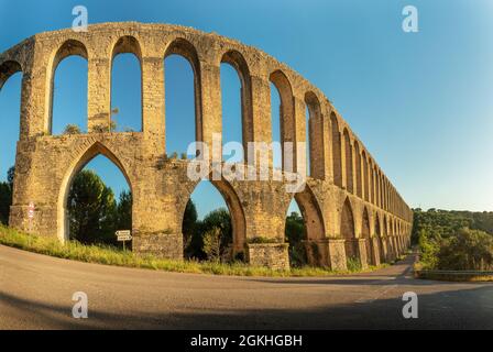 Vista panoramica dell'acquedotto di Pegões, vicino alla città di Tomar in Portogallo, illuminata dal sole alla fine della giornata con un cielo blu sullo sfondo. Foto Stock