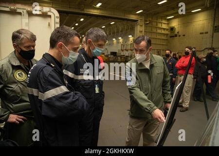 ADM posteriore. Craig Clapperton, destra, comandante, Carrier Strike Group (CSG) 12, briefing francesi Armaments Procurements Agency (DGA) membri di USS Gerald R. Ford (CVN 78) armi avanzate ascensori nella baia di hangar durante un tour della nave, 24 aprile 2021. La dirigenza DGA ha visitato Ford per vedere il sistema di lancio degli aeromobili elettromagnetici (EMALS) e l'avanzato dispositivo di arresto (AAG) in funzione, per consentire alla Francia di perfezionare il design del futuro vettore francese. L'approvvigionamento di EMALS e AAG da parte della Francia e l'adozione di un modello di operazioni di volo su ponte di classe Ford garantiranno il proseguimento dell'interoperabilità Foto Stock