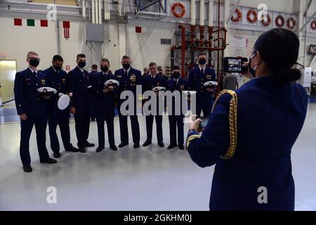 Comandante della Guardia Costiera ADM. Karl L. Schultz si presenta con un gruppo di membri dell'equipaggio della Guardia Costiera Cutter Douglas Munro a seguito della cerimonia di smantellamento della nave tenutasi a Kodiak, Alaska, il 24 aprile 2021. Prima dello smantellamento della nave, gli equipaggi trascorrerebbero circa 185 giorni dell'anno in corso per l'esecuzione delle loro missioni. Foto Stock