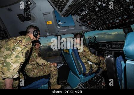 Il 1° Lt. Samuel Braun, il capitano dell'aeronautica statunitense Brian Bilbo, e il 1° Lt. Christopher Hixson, tutti i piloti C-17 Globemaster III assegnati al 15° Squadron Airlift, si preparano per il loro atterraggio sulle Hawaii, 24 aprile 2021. Il 15° Airlift Squadron ha condotto una missione di canale per la consegna del carico alla base dell'aeronautica di Travis, CA, Joint base Pearl Harbor-Hickam, Hawaii, e alla base aerea di Kadena, Giappone. Questo tipo di missione di routine garantisce che i membri dell'equipaggio siano in grado di offrire una rapida mobilità globale in ogni momento. Foto Stock