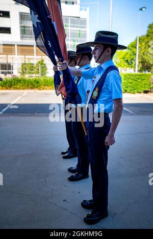 I cadetti con la Royal Australian Air Force trasportano le bandiere di Australia, Nuova Zelanda e del territorio del Nord durante una parata di giorno di Anzac a Palmerston City, NT, Australia, 25 aprile 2021. Anzac Day ha originariamente commemorato le forze del corpo militare australiano e neozelandese della prima guerra mondiale, ma ora riconosce anche gli uomini e le donne che hanno servito nei servizi armati australiani e neozelandesi in tutte le guerre, conflitti e operazioni di mantenimento della pace. Gli impegni della comunità del corpo Marino degli Stati Uniti nel territorio del Nord e in tutto il paese aggiungono profondità al nostro rapporto con l'Australia e highl Foto Stock