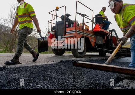 Un equipaggio di costruzione ripagella una strada per coprire le linee fognarie appena completate per un progetto di infrastruttura idrica parzialmente finanziato nell'ambito del Water Resource Development Act del 1936, ad Amsterdam, Ohio, 28 aprile 2021. Il corpo dell'esercito degli Stati Uniti degli ingegneri Pittsburgh District supervisiona progetti come questo, che aiuta le comunità in difficoltà a ricevere assistenza federale sotto la WRDA. Il distretto ha visto una crescita della domanda di infrastrutture idriche e fognarie e ha approvato nove nuovi progetti idrici nella Contea di Allegheny e nella Virginia del Nord Ovest negli ultimi tre anni sotto la Sezione 219. L'Ohio orientale è coperto da sec Foto Stock