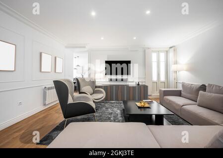 Soggiorno di appartamento affitto per le vacanze con sedie ad ala e televisione sullo sfondo Foto Stock