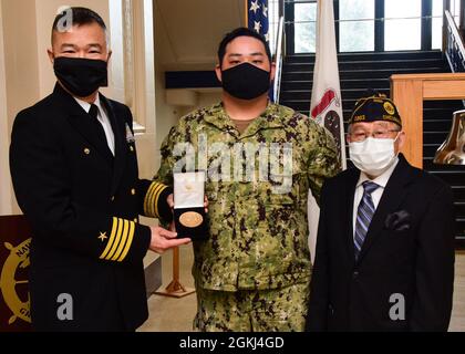 GRANDI LAGHI, il. (Aprile 29, 2021) il Capitano Raymond Leung, comandante della base navale Great Lakes, presenta la Medaglia d'oro del Congresso a Fire Controlman di terza classe Jeffrey Tan e suo nonno, Frank Wong, a nome del bisnonno di Tan, Jin Wong, per il suo servizio nell'esercito degli Stati Uniti durante la seconda guerra mondiale . Questa presentazione fa parte del Chinese-American World War II Veteran Project, una campagna nazionale per identificare, onorare e riconoscere i risultati di tutti i cinesi-americani che hanno servito nelle forze armate degli Stati Uniti durante la seconda guerra mondiale Foto Stock