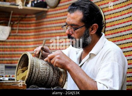 Damasco, Siria. 14 settembre 2021. Un artigiano produce una pentola di ottone intarsiato d'argento nella sua bottega a Damasco, Siria, il 14 settembre 2021. Credit: Ammar Safarjalani/Xinhua/Alamy Live News Foto Stock