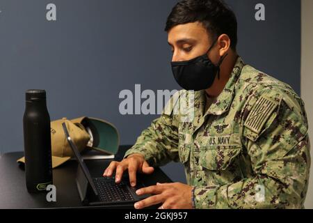 Il funzionario statunitense della Marina di Petty di terza classe Kevin Serna, un tecnico elettronico per l'aviazione di Houston, Texas, assegnato alla USS Boxer (LHD 4), firma un membro della comunità Tulsa nel Community Vaccine Center (CVC) presso il Tulsa Community College Northeast Campus di Tulsa, Oklahoma, 1° maggio 2021. I marinai che hanno affidato il CVC di Tulsa provenivano dal USS Boxer (LHD 4), dalla USS Comstock (LSD-45), dalla USS Harpers Ferry (LSD-49) e dal Naval Medicine and Readiness Training Command di San Diego. Il comando del Nord degli Stati Uniti, attraverso il Nord dell'esercito degli Stati Uniti, rimane impegnato a fornire su del Dipartimento della Difesa, continuo e flessibile Foto Stock