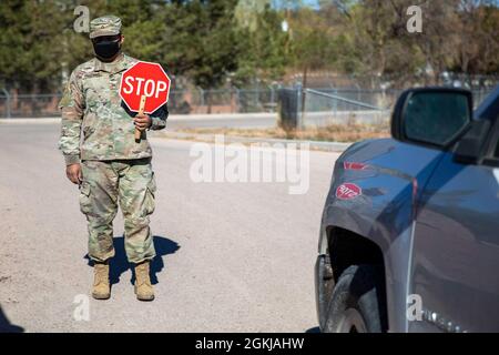 Un soldato della Guardia Nazionale dell'Esercito dell'Arizona dirige il traffico in un sito di distribuzione alimentare a ft. Defiance, Ariz. Sulla Nazione Navajo, 30 aprile 2021. Più di 900 soldati cittadini dell’Arizona e Airmen continuano a viaggiare in tutto lo stato per assistere le comunità nei siti di vaccinazione e nelle banche alimentari. Foto Stock