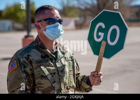 Personale Sgt. Trever Stanton, un operatore di trasporto a motore con la 222a compagnia di trasporto della Guardia Nazionale dell'Arizona, dirige il traffico in un sito di distribuzione alimentare a ft. Defiance, Ariz., sulla Nazione Navajo, 30 aprile 2021. Stanton, che fa parte della missione COVID-19 da quando è iniziata nel marzo 2020, ha detto: “per me, si tratta di aiutare la mia comunità. Tutti stanno lottando ora, e ho voluto uscire qui e aiutare in qualsiasi modo potrei. Siamo qui per aiutare la Nazione Navajo a costruire la loro forza durante questa pandemia”. Foto Stock