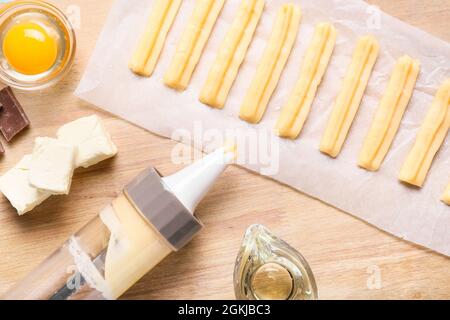 Churros non cotti e ingredienti su sfondo di legno Foto Stock