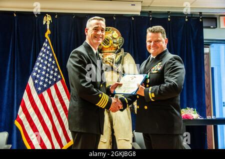 Steven Antcliff, comandante della Naval Submarine School, presenta un premio di fine tour in occasione del ritiro del Chief Warrant Officer 3 Mark Cooper durante una cerimonia a bordo della Naval Submarine base New London, Groton, CT, il 30 aprile 2021. Con la funzione di ufficiale subacqueo presurizzato Submarine Escape Trainer di SUBSCOL, Cooper si è ritirato dopo oltre trenta anni di servizio nella Marina degli Stati Uniti. È stato un leader di consumo e una figura critica nel mantenimento della qualità dell'istruzione all'interno del reparto di formazione ad alto rischio di SUBSCOL. Foto Stock