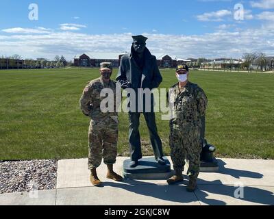 Michael poss, ufficiale comandante dell'esercito degli Stati Uniti Fort McCoy, è in piedi con il comando di addestramento della Marina degli Stati Uniti Capitano Erik Thors di fronte alla statua di Lone Sailor della Marina in Great Lakes, Il Lone Sailor è una copia della statua originale in bronzo scolpita da Stanley Bleifeld per il U.S. Navy Memorial a Washington, D.C. Foto Stock