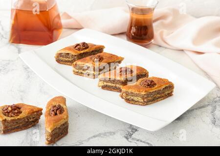 Piatto con gustoso baklava su sfondo chiaro Foto Stock