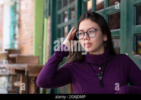 Adolescente con acen che si posa con sicurezza in strada urbana. Concetto di anni scomodi. Foto Stock