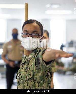 Un reclutamento esegue un vestito al comando di sinistra durante la pratica di perforazione all'interno di un compartimento delle caserme di reclutamento di USS Enterprise al comando di addestramento di reclutamento. Più di 40,000 reclute si allenano ogni anno presso l’unico campo di stivali della Marina. Foto Stock