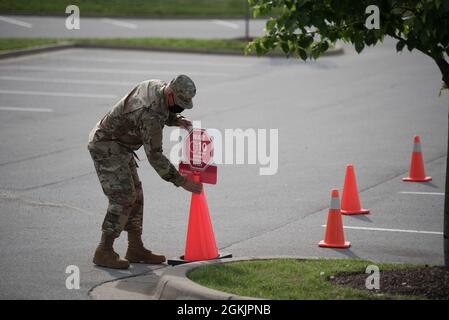 Il Senior Master Sergeant Krome Raymond, sovrintendente al trasporto aereo con il 123esimo Squadrone della Logistics Readiness della Guardia Nazionale del Kentucky Air, crea coni stradali in un sito di vaccinazione mobile COVID-19 di un giorno presso l'Outlet Shoppes del Bluegrass di Simpsonville, Ky., il 6 maggio 2021. Il sito è stato gestito dall'Università di Louisville e supportato da Airmen della 123a Airlift Wing. Torneranno a Simpsonville il 27 maggio per i successivi colpi di vaccinazione. Foto Stock