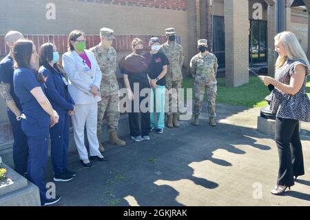 Da sinistra: Jaci Crouch, Timothy Locklear, April Newman, Kie McNabb, Lt. Col. Dwight Berry, Amelia Ross, Danee Cook, CPT. Janshay Polk e Major Carmen Salcedo, infermieri registrati del Beauregard Health System, Bayne-Jones Army Community Hospital e 3 ° Brigade Combat Team, 10 ° Divisione montagna Ascolta il sindaco Misty Clanton mentre legge la proclamazione della settimana delle infermiere presso il municipio di DeRidder, Louisiana, il 6 maggio. Foto Stock