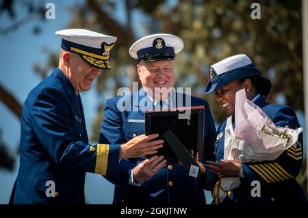 ADM posteriore. Brian K. Penoyer, l'undicesimo comandante del distretto, condivide una risata con il direttore generale Petty Officer Phadra Y. Hooker e il direttore generale Petty Officer Richard S. Hooker durante una cerimonia di cambio di guardia a Coast Guard Island ad Alameda, California, 7 maggio 2021. La cerimonia del cambio di guardia è una tradizione ormai consolidata e garantisce la continuità della leadership nell’area di responsabilità del distretto. Foto Stock