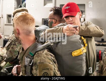 Un paracadute rigger assegnato alla 11th Quartermaster Company, Special Troues Battaglione, 82nd Airborne Division Sogade regola un paracadute T-11 a bordo di un aereo C-17 Globemaster III diretto per l'Estonia durante Swift Response 21, 7 maggio 2021. Swift Response 21 è un esercizio congiunto e multinazionale di Airborne che coinvolge oltre 7,000 paracadutisti provenienti da 10 nazioni della NATO. Foto Stock