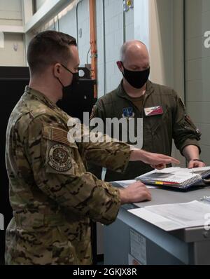 Air National Guard Pilot, Lt. Col. Rob Gearhart e loadmaster, Master Sgt. Nick Dislavo, della 143d Airlift Wing, rivedere i documenti di formazione per il sistema di armi Trainer-Reconfigururable, Quonset Air National Guard base, North Kingstown, R.I., 7 maggio 2021. Il WST10R offre la possibilità di connettersi con altre unità di tutto il mondo per volare missioni insieme a scenari realistici e pertinenti. Foto Stock