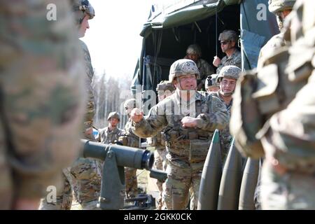 Esercito degli Stati Uniti Sgt. 1a classe Ryan Pizzingrilli, assegnato a Charlie Battery, 1° Battaglione, 319° Reggimento artiglieria da campo Airborne, 3° Team di combattimento Brigade, 82a Divisione Airborne, parla con i soldati britannici del 7° Regimento Paracadutes, Artiglieria Royal Horse di tecniche adeguate di movimentazione delle munizioni con le conchiglie da 155 mm a Tapa Central Training Area, Estonia, Maggio 10, 2021. SWIFT Response 21 è un esercizio collegato di DEFENDER-Europe 21, che prevede attività operative speciali, aggressioni aeree ed esercitazioni antincendio in Estonia, Bulgaria e Romania, dimostrando l'interoperabilità aerea Foto Stock