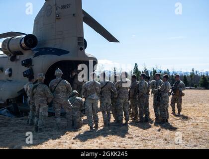 A US Army CH-47 Chinook capo equipaggio assegnato a B Company, 1 ° Battaglione, 52 ° Regiment Aviazione, briefing US Army paracadutisti con il 1 ° Battaglione, 501 ° Regiment di fanteria paracadutismo, 4 ° squadra di combattimento Brigata fanteria (Airborne), 25 ° Divisione fanteria, in procedure di uscita in un campo vicino a Fort Wainwright, Alaska, Prima di un'operazione di inserimento scout a supporto del bordo settentrionale 2021, 10 maggio 2021. Circa 15,000 membri del servizio degli Stati Uniti partecipano a un esercizio di addestramento congiunto ospitato dalle forze aeree del Pacifico degli Stati Uniti dal 3 al 14 maggio 2021, su e sopra il complesso Joint Pacific Alaska Range, il GU Foto Stock