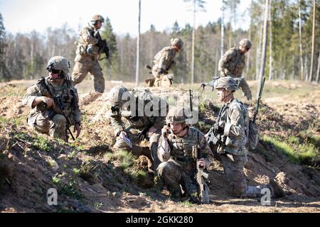 Un soldato britannico con 7° reggimento di paracadute, Royal Horse Artillery parla alla radio durante l'addestramento con soldati dell'esercito degli Stati Uniti assegnati a Bravo Company, 1° battaglione, 508° reggimento di fanteria di paracadute, 3° squadra di combattimento di brigata, 82a divisione Airborne, mentre conducendo manovre di platoon durante Swift Response 21 presso l'Area di addestramento centrale di Tapa, Estonia, 11 maggio 2021. SWIFT Response 21 è un esercizio collegato di DEFENDER-Europe 21, che prevede attività operative speciali, aggressioni aeree ed esercitazioni antincendio in Estonia, Bulgaria e Romania, dimostrando l'interoperabilità aerea tra la NATO A. Foto Stock