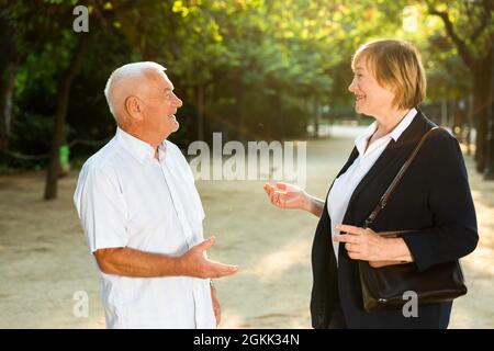 Coppia anziana che parla emotivamente nel parco Foto Stock