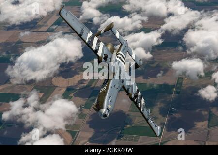 Un pilota con il 190° Fighter Squadron, 124° Fighter Wing, Boise, Idaho, vola un A-10 Thunderbolt II con un nuovo schema di verniciatura del patrimonio mondiale della seconda guerra mondiale dipinto dall'impianto di verniciatura della Air National Guard di Sioux City, Iowa, alla sua nuova sede presso la Idaho Air National Guard, Gowen Field, Idaho, 12 maggio 2021. La nuova vernice presenta strisce di invasione bianche e nere proprio come quelle dipinte su P-47 Thunderbolts la sera del 4 giugno 1944 e utilizzate per aiutare gli antiaerei americani a distinguere tra combattenti alleati e nemici durante l'invasione del D-Day. Foto Stock